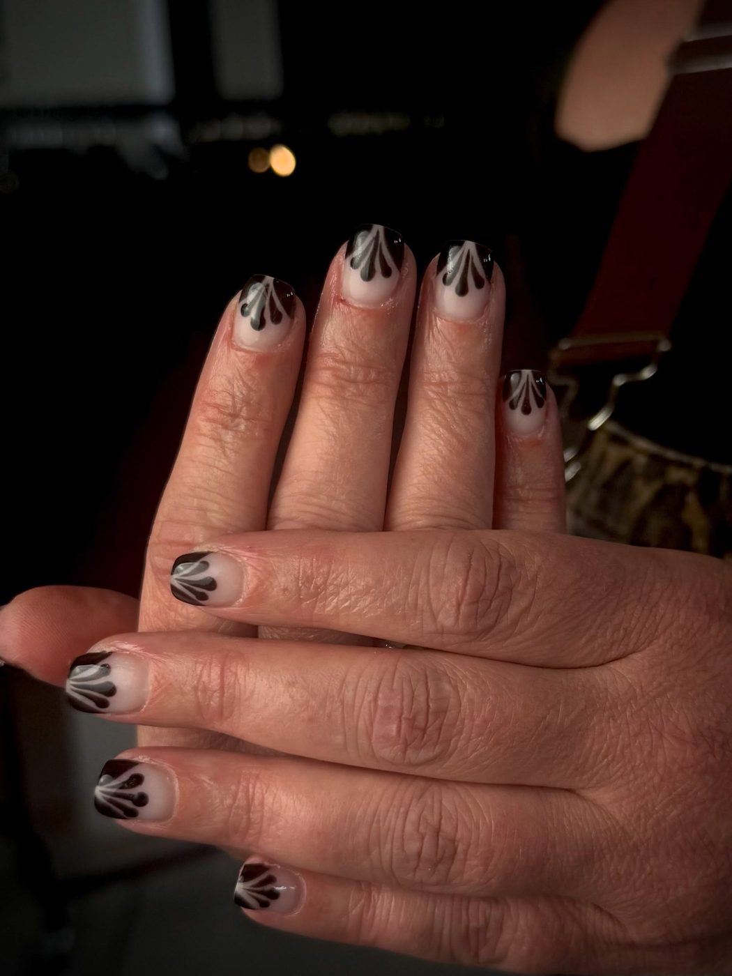 Korte nagels met grijze bloemmotieven die uitlopen naar transparant