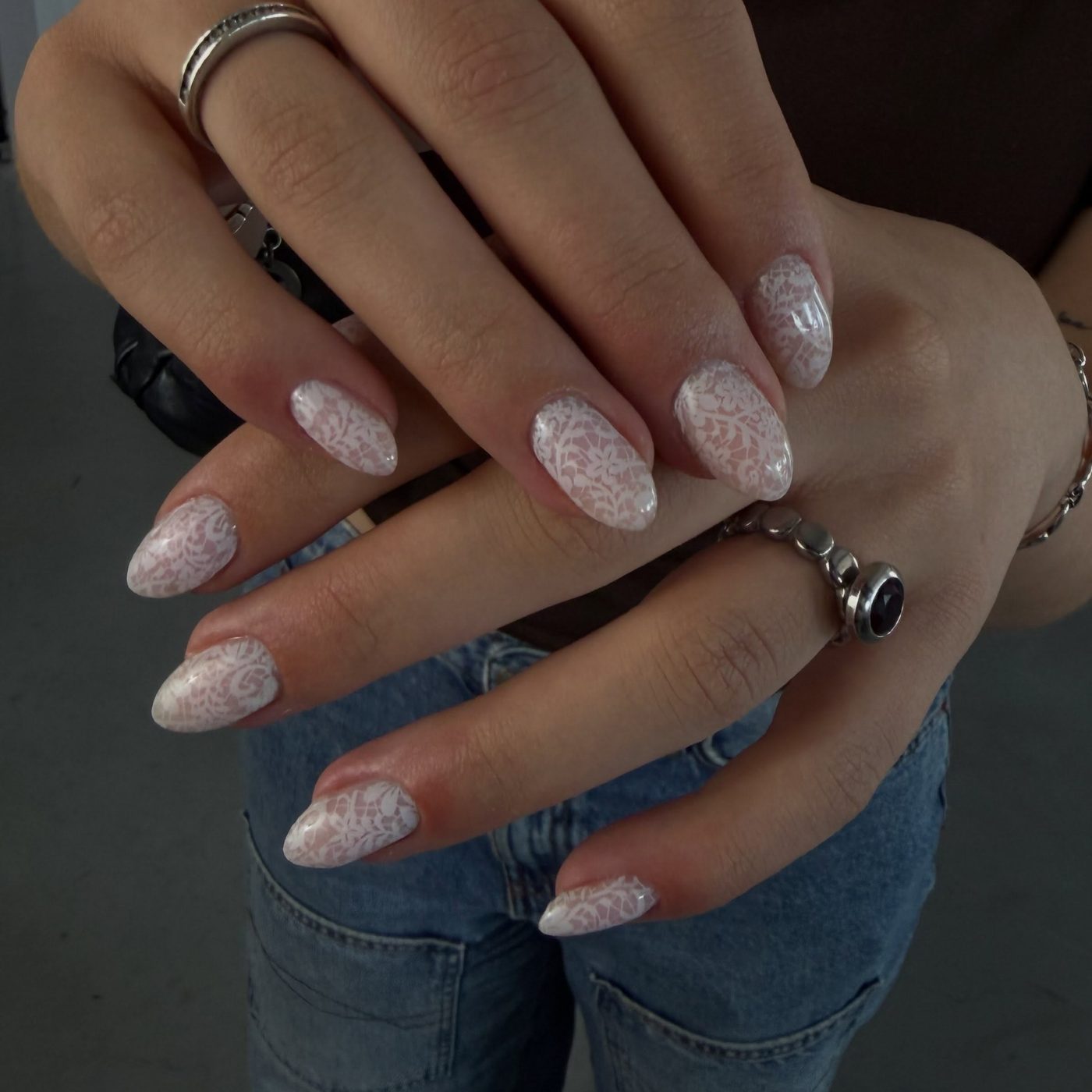 Melkwitte amandelnagels met een kanten patroon