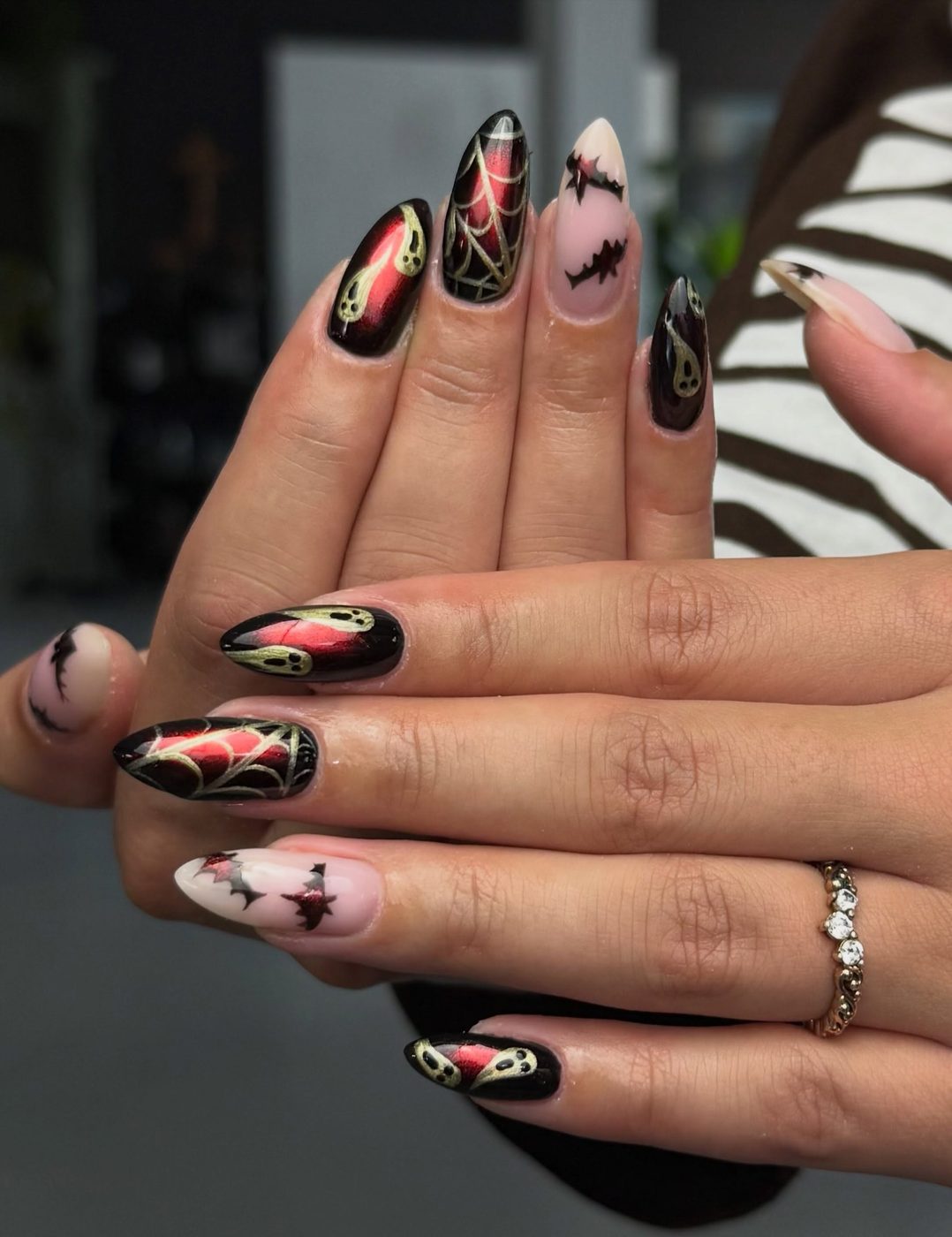 Zwarte nagels met rode spinnenwebben en kleine vleermuisjes